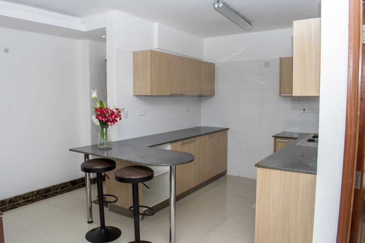 Modern open-plan kitchen with island bar seating and natural wood cabinetry