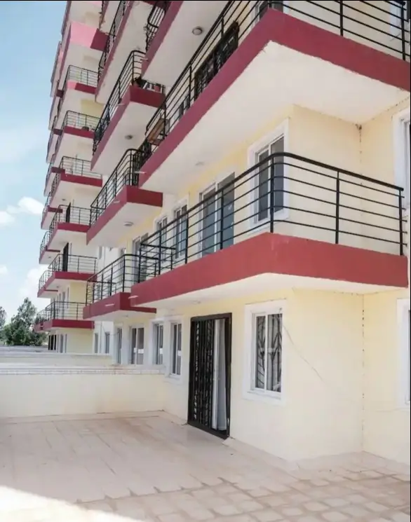Modern apartment building facade with red accents and balconies