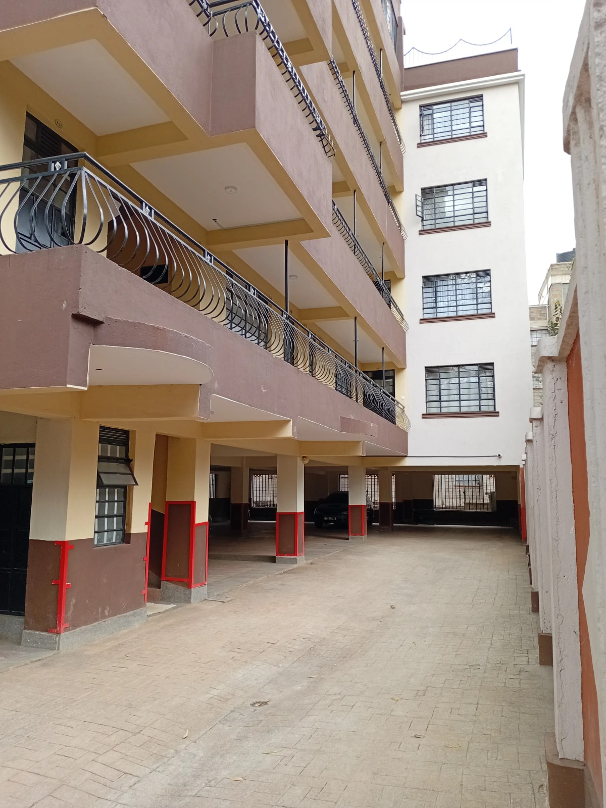 Multi-story apartment building compound with ground-level parking area