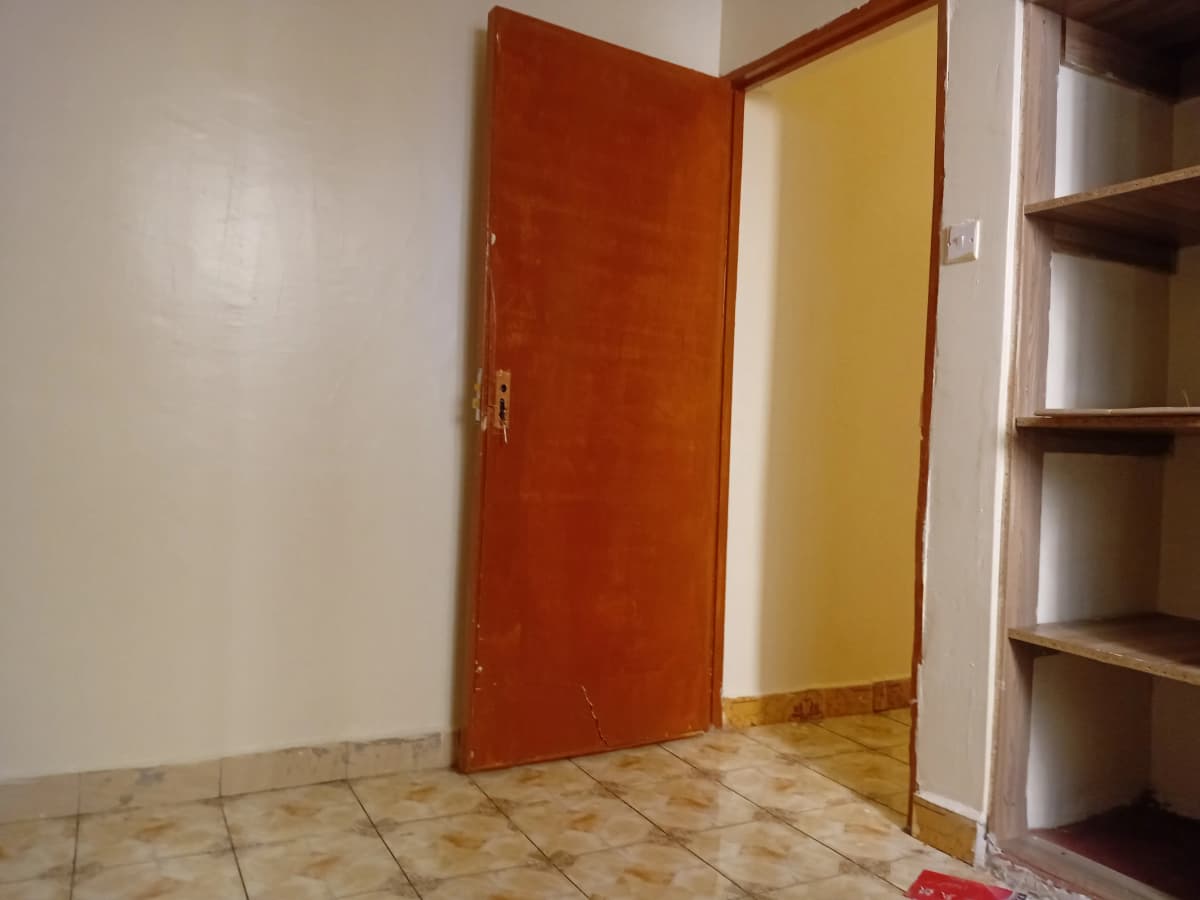 Empty bedroom with tiled floor and colored doors