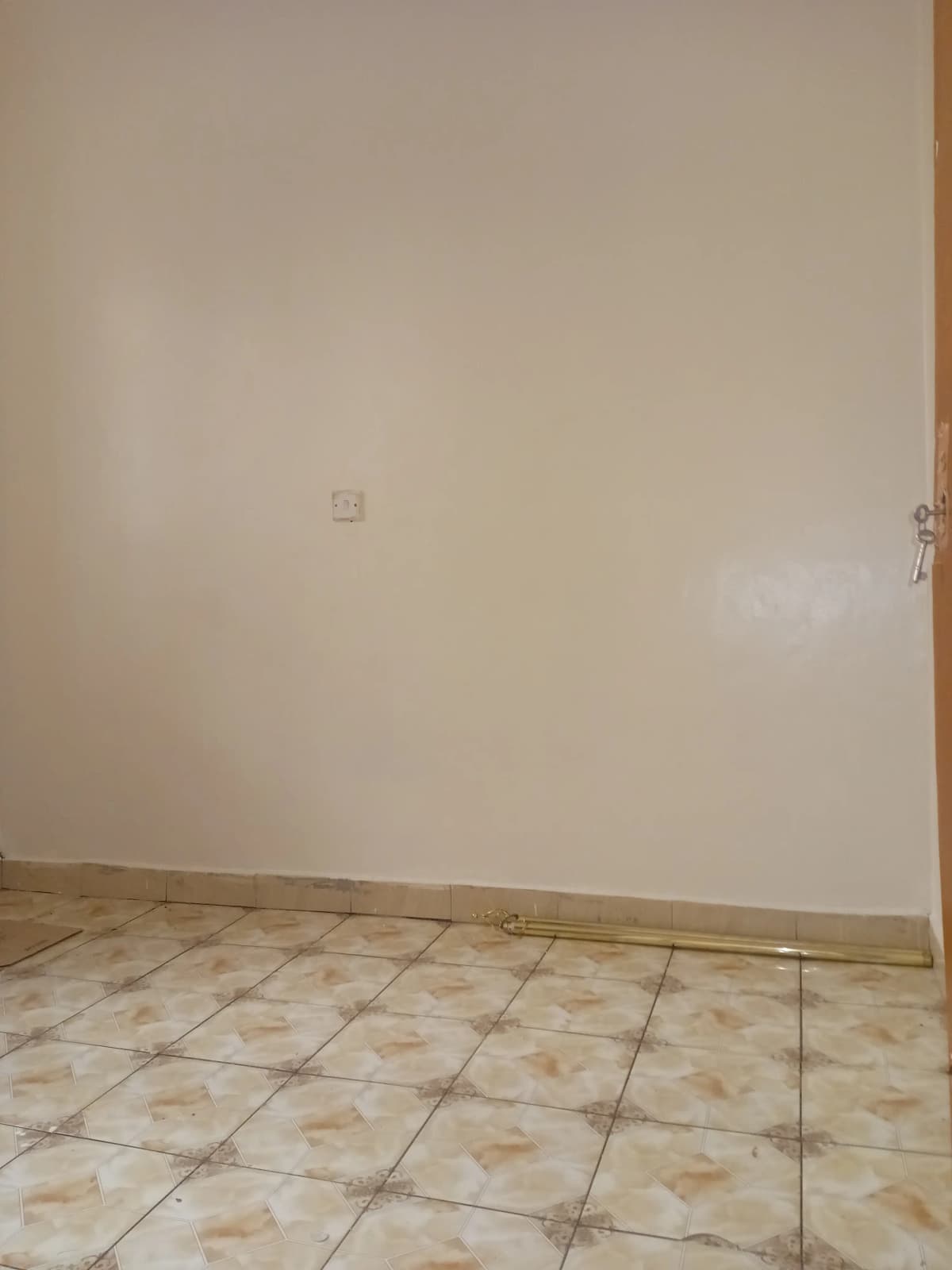 Empty room with beige tile flooring and plain walls