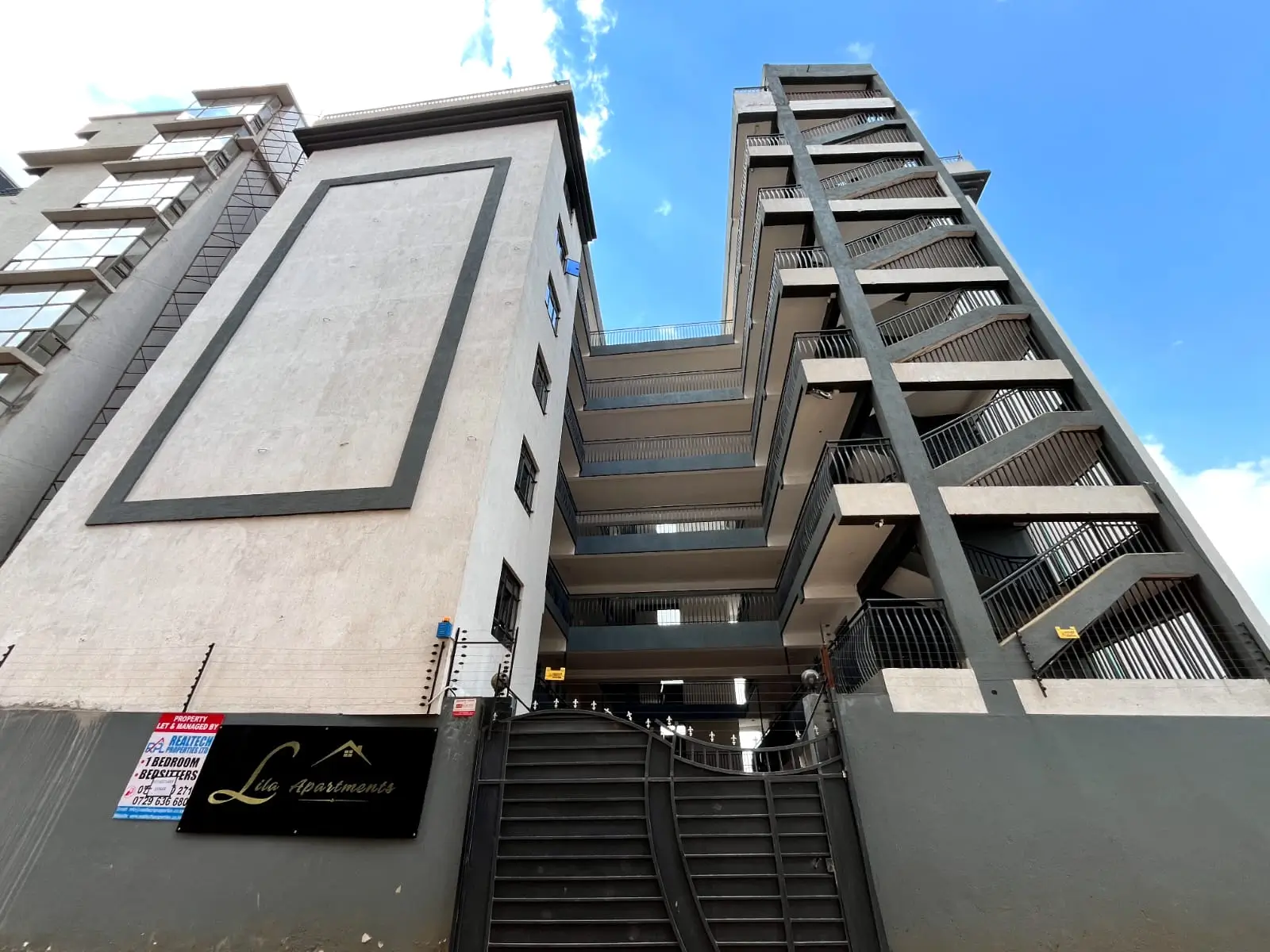 Modern apartment building facade with entrance gate and stairs