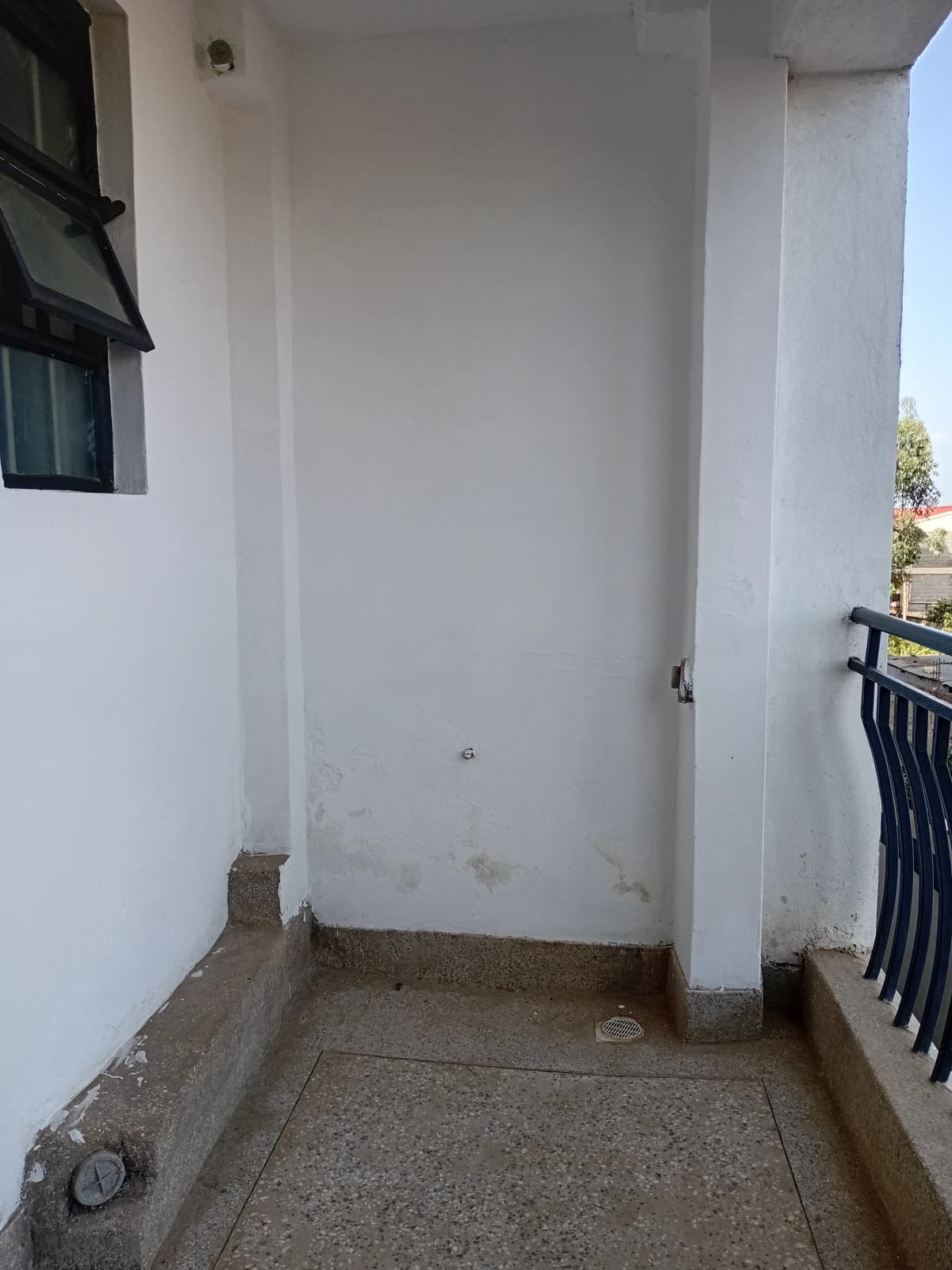 Narrow covered outdoor balcony with concrete floor