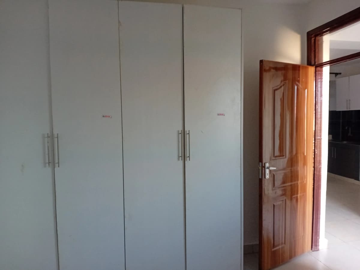 Bedroom with large built-in white wardrobes and wooden door