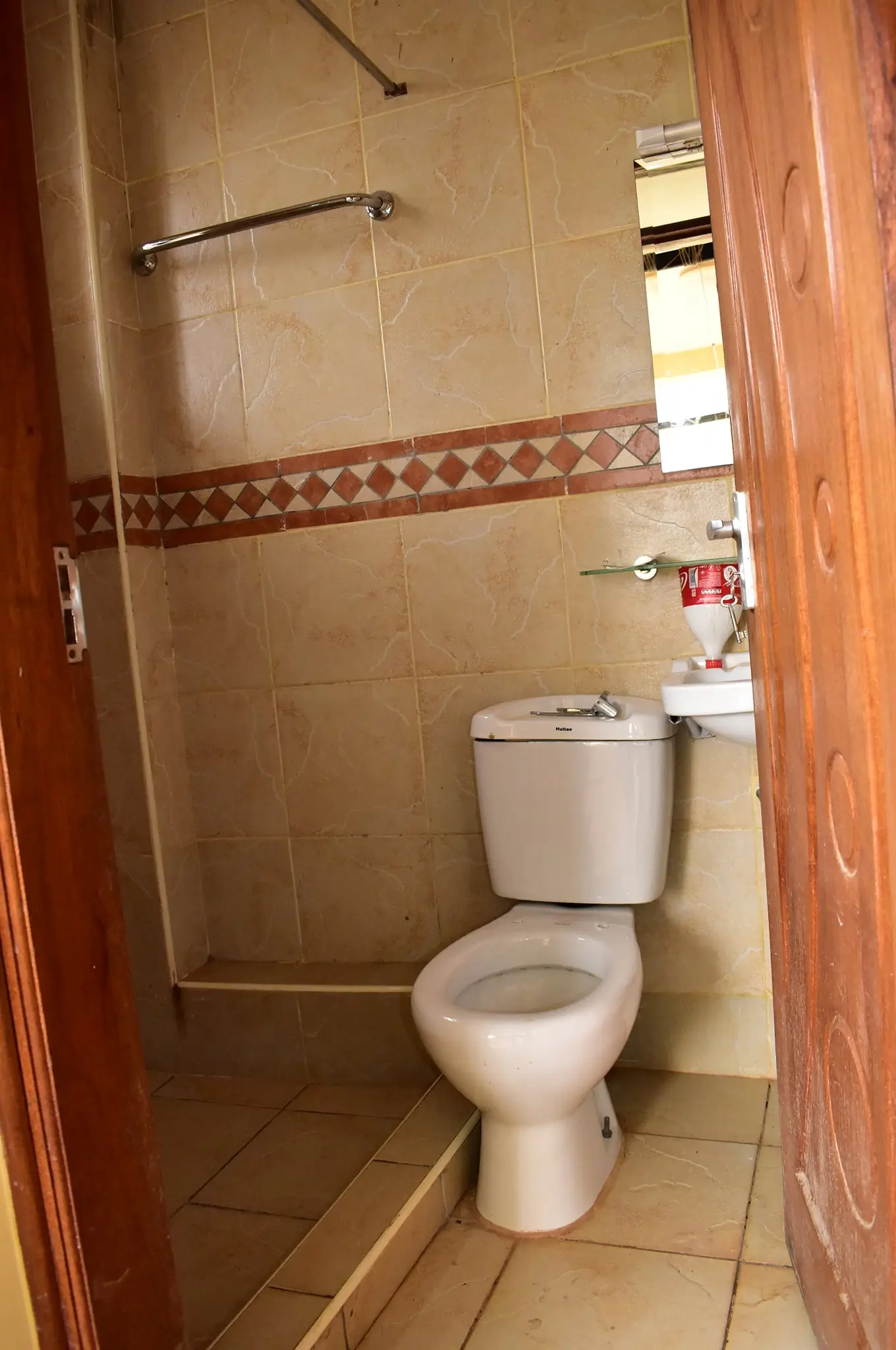 Compact bathroom with toilet, sink, and walk-in shower