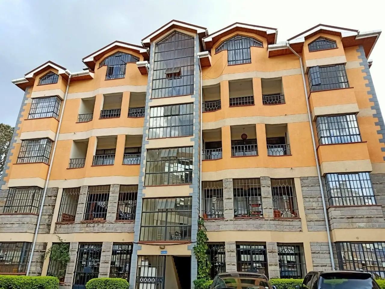 Multi-story residential building facade with orange and cream exterior