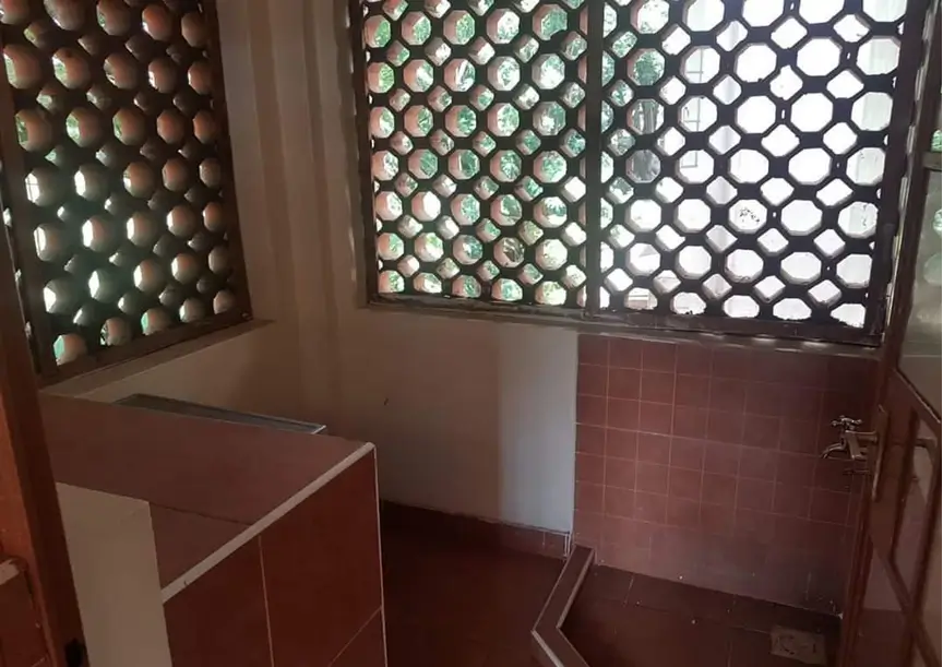Utility storage room with metal mesh shelving and tile flooring
