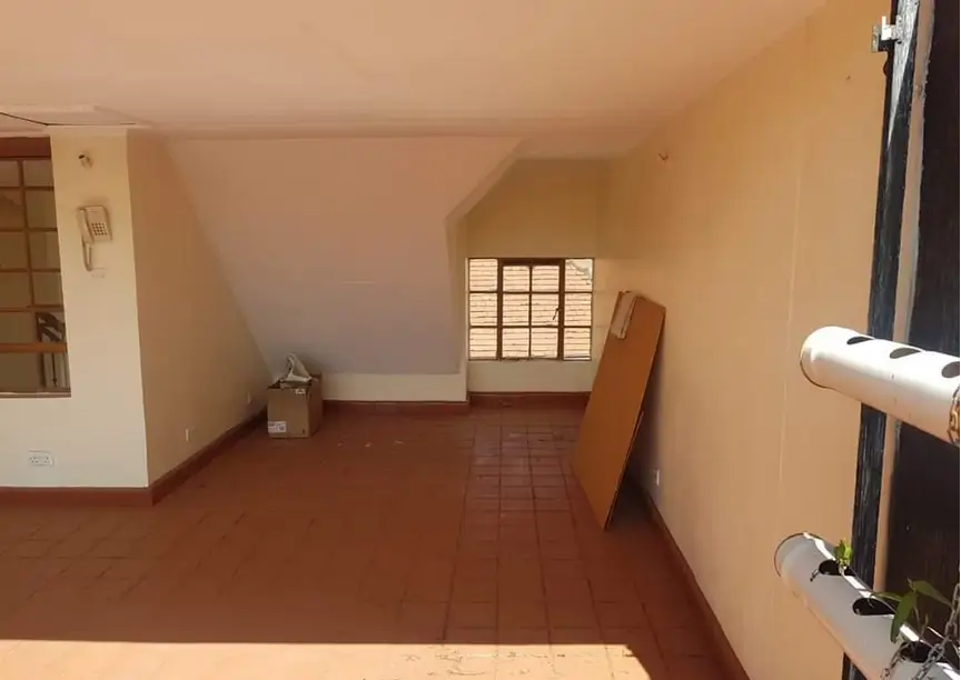 Spacious bedroom with terracotta tile floor and natural light