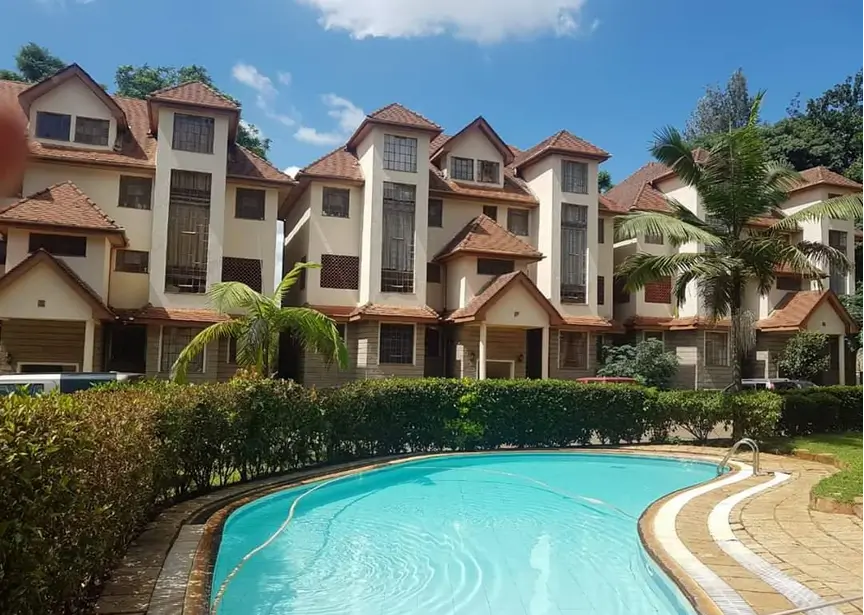 Large curved swimming pool with residential compound backdrop