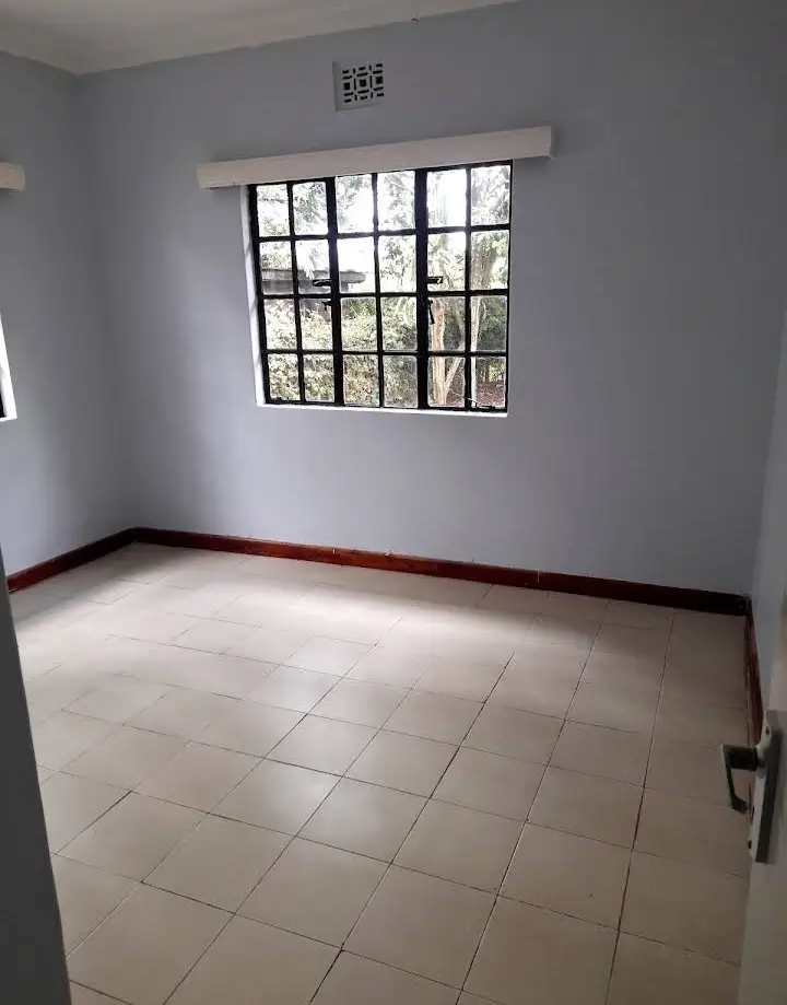 Spacious bright bedroom with large grid windows and tiled floors