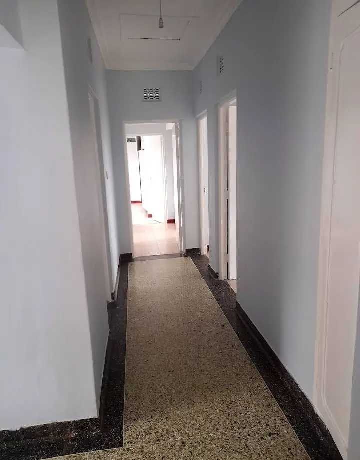 Long hallway with white walls and dark polished concrete floor