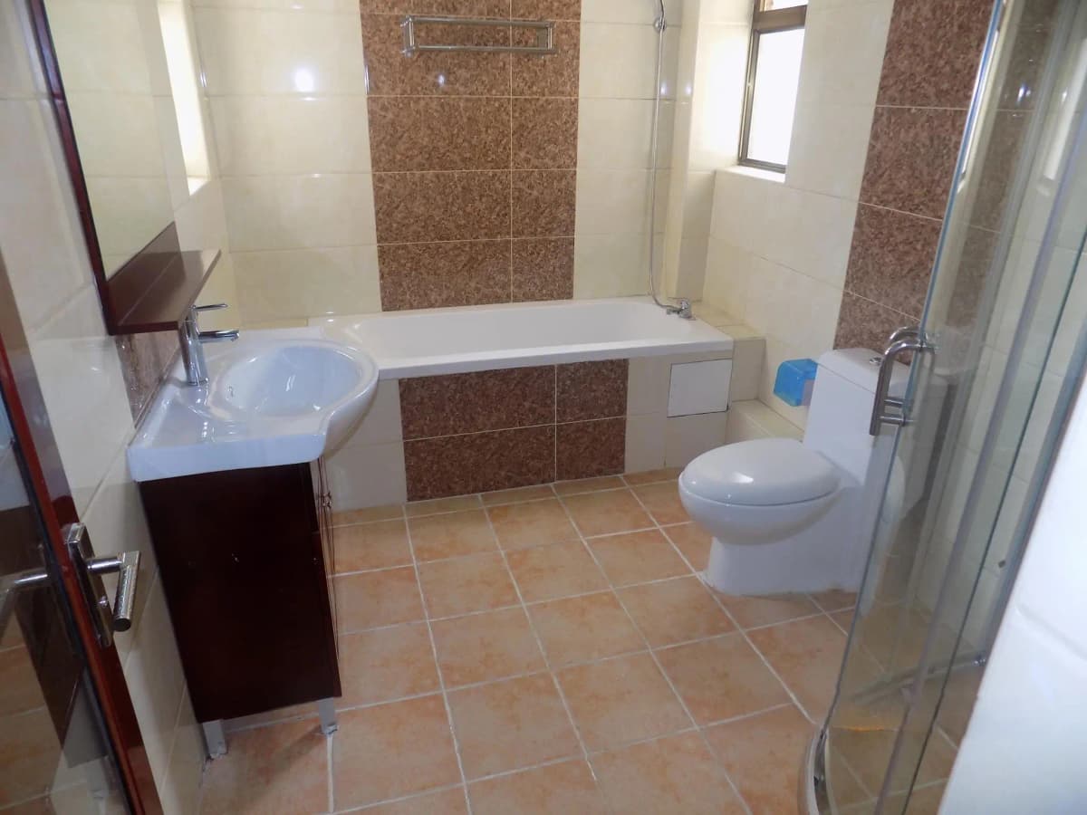 Spacious bathroom with bathtub, dual sink vanity, toilet