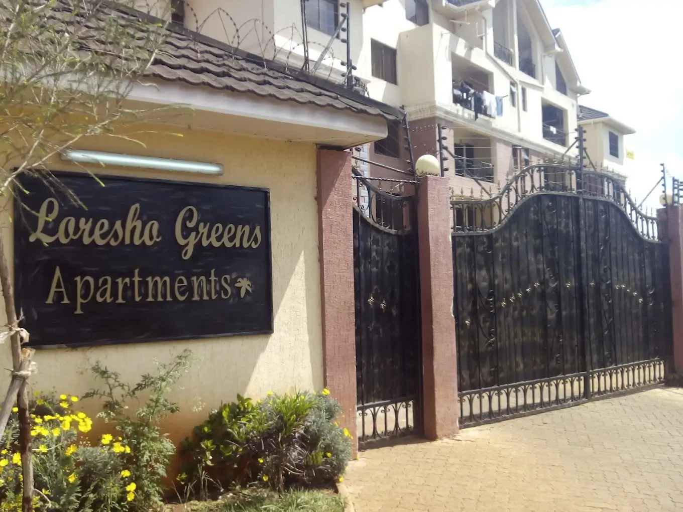 Apartment building entrance with branded gate and compound signage
