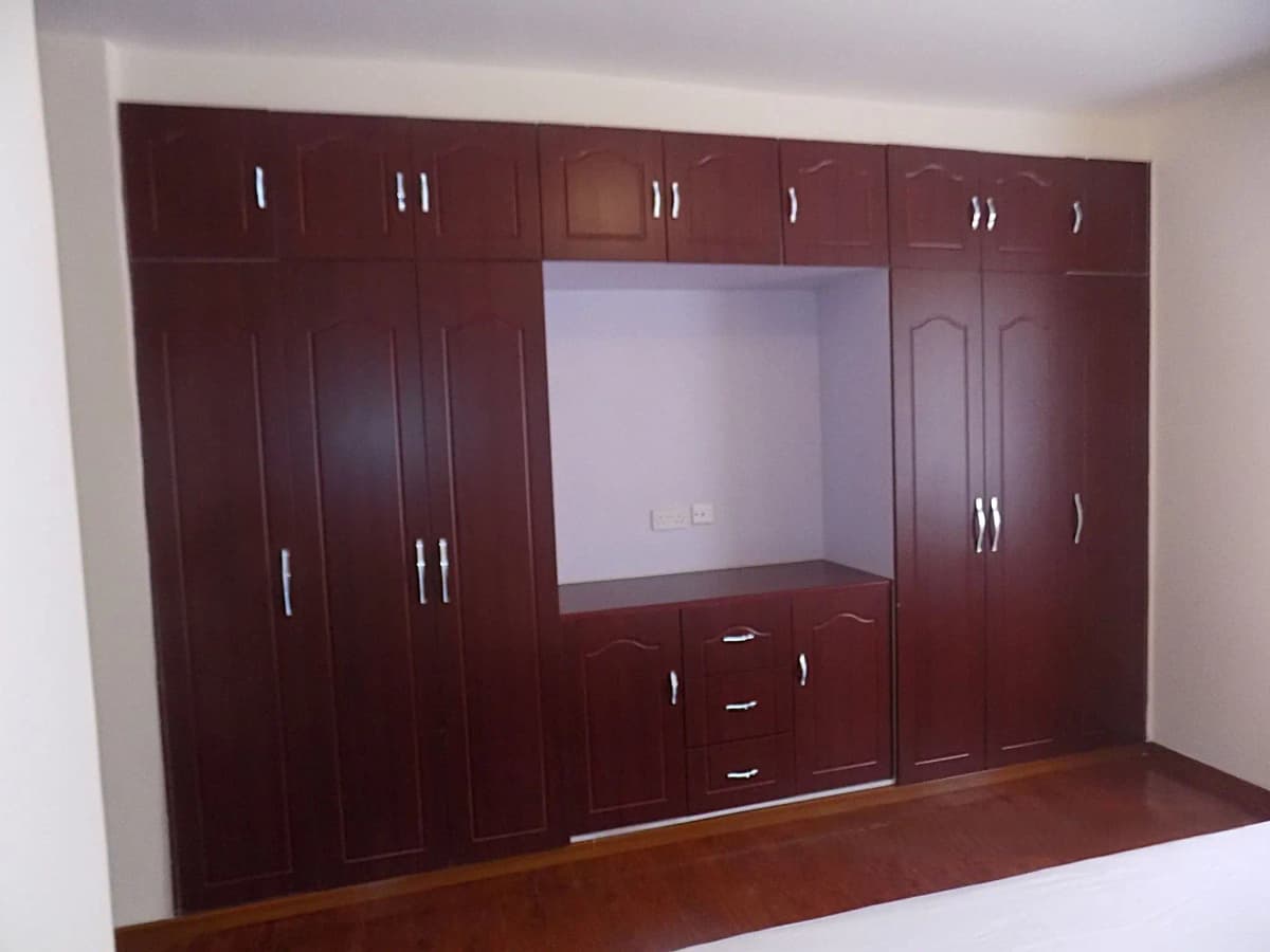 Bedroom with built-in dark wood wardrobe and entertainment unit