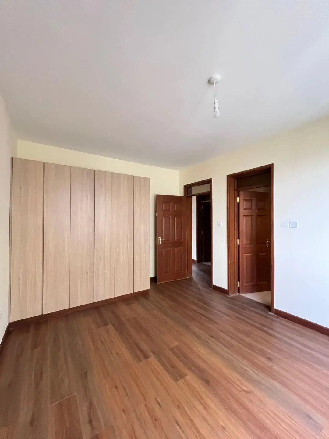 Spacious bedroom with built-in wardrobe and wooden flooring