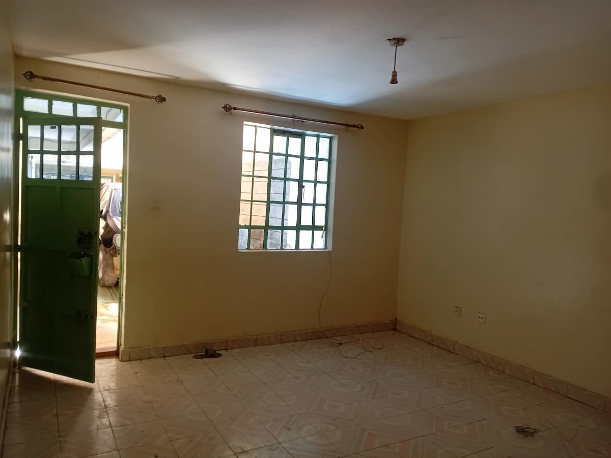 Empty living room with green door and bright windows