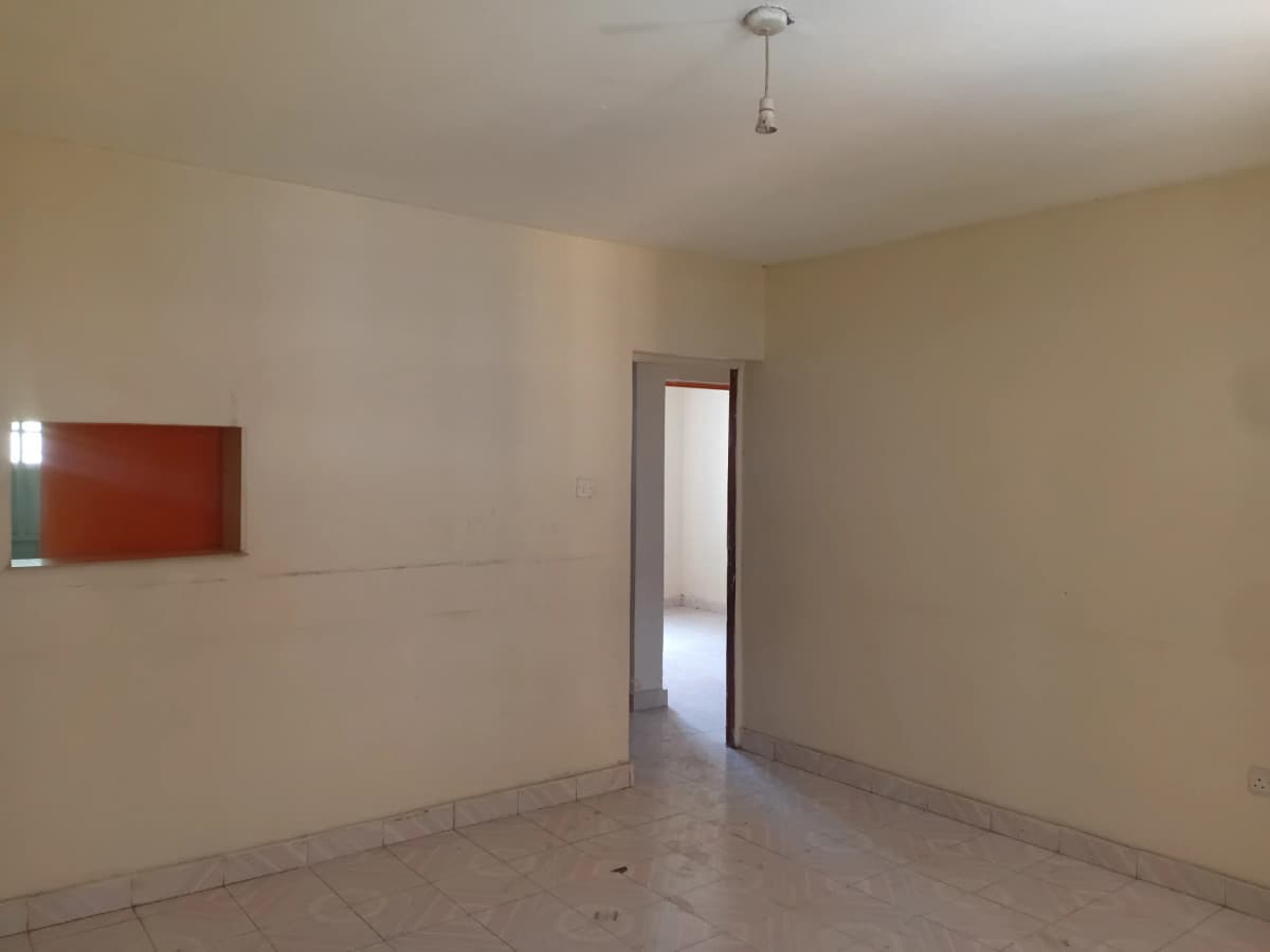 Empty living room with cream walls and tiled floor
