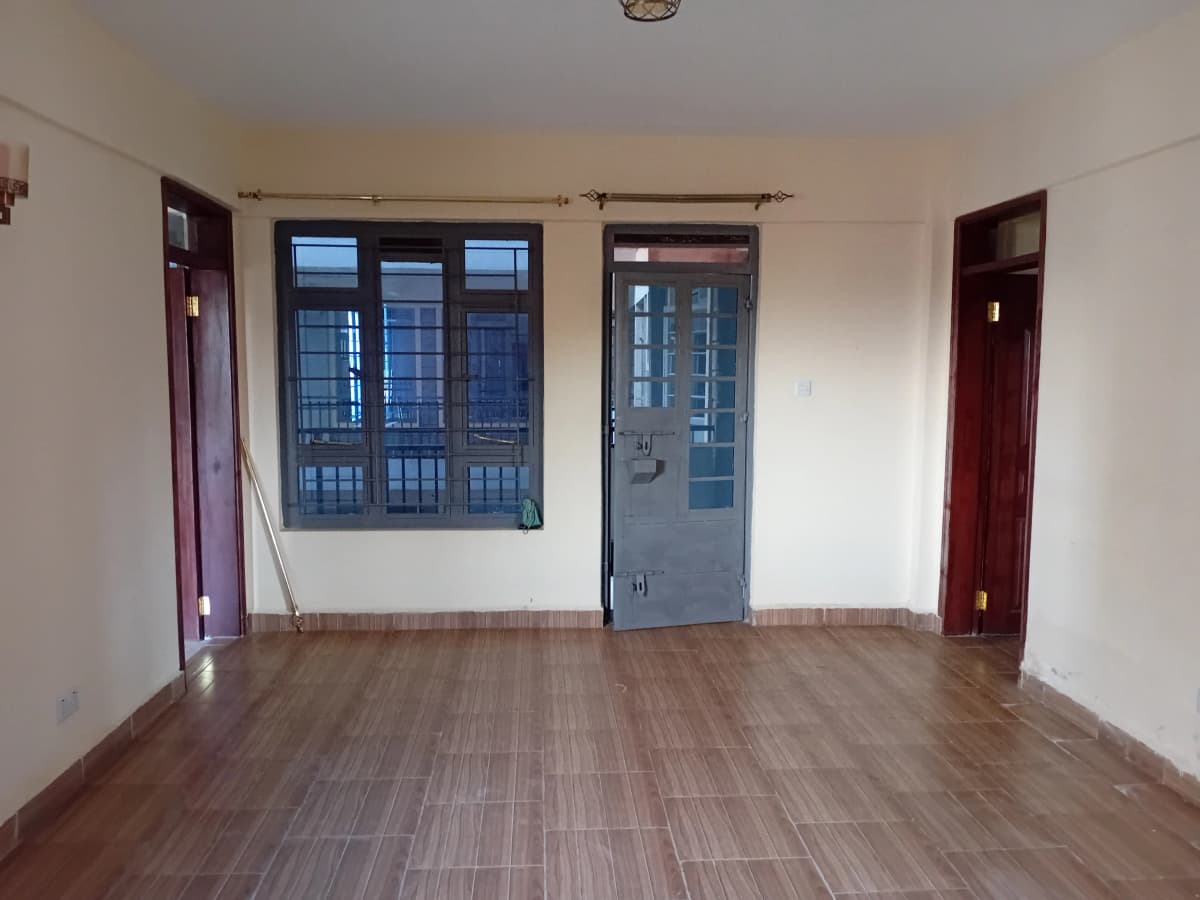 Spacious empty living room with wooden flooring and large windows