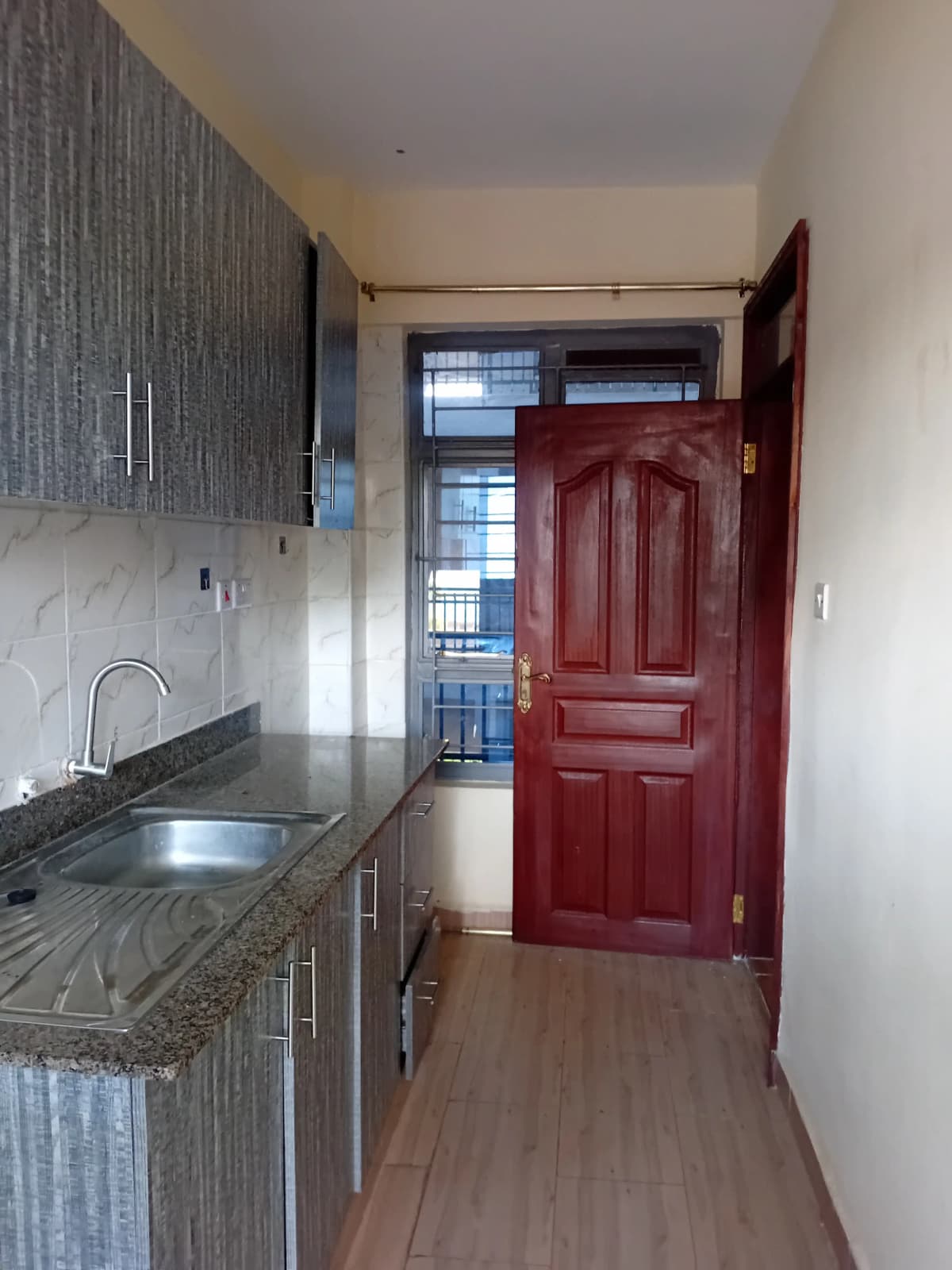 Galley kitchen with gray cabinetry and granite countertop