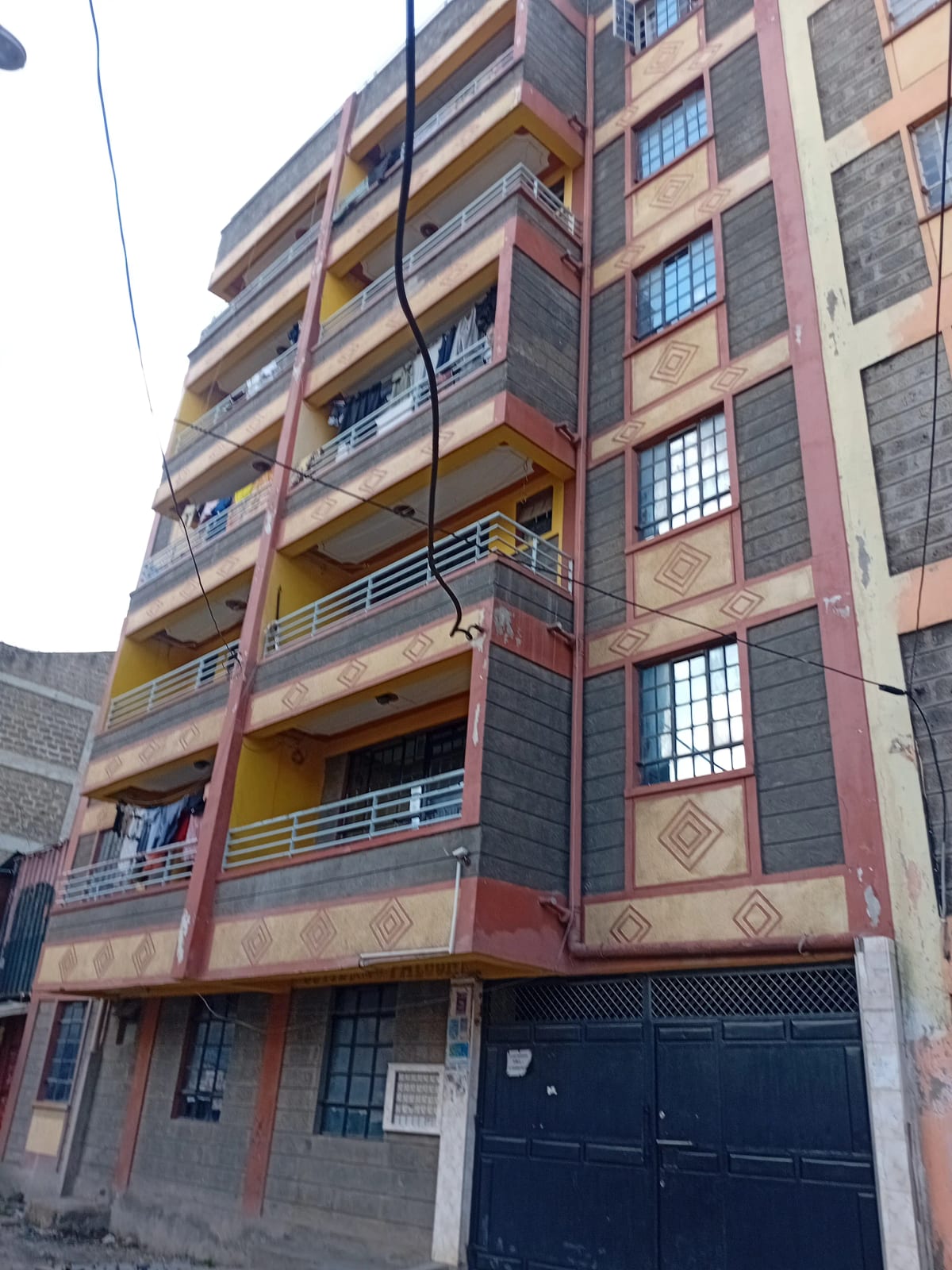 Multi-story residential building facade with balconies and ground-floor garage