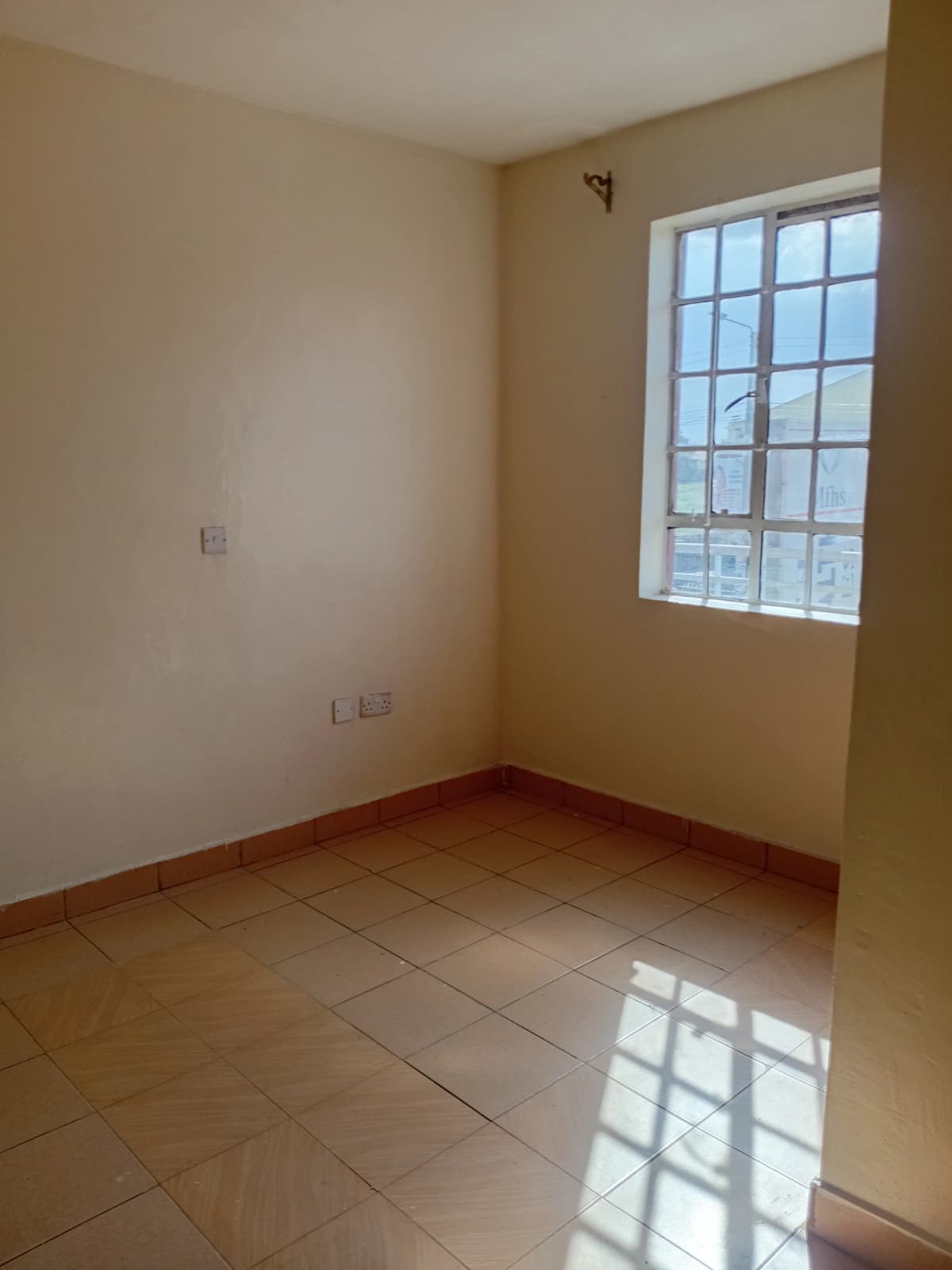 Bright bedroom with large window and tiled floor