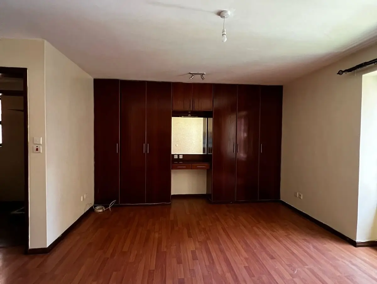 Spacious bedroom with built-in dark wood wardrobe