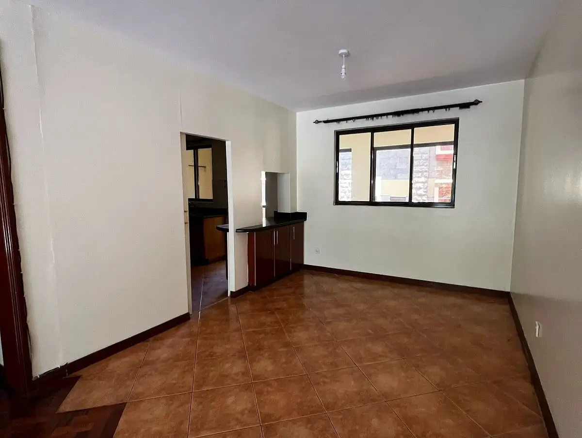 Spacious living room with terracotta tile flooring and natural light