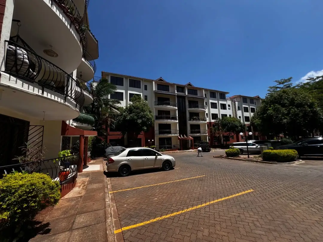 Multi-story residential compound with parking area and landscaping