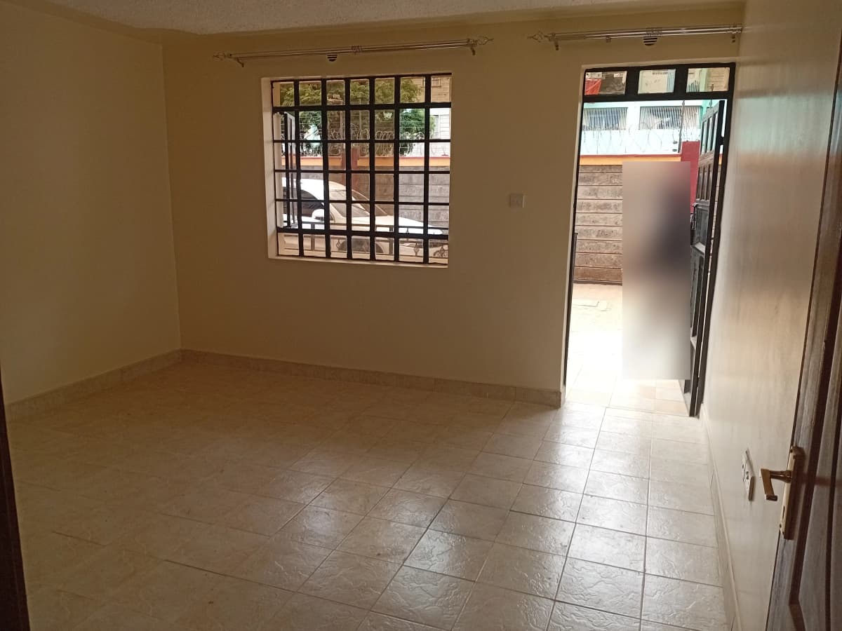 Spacious empty living room with tiled flooring and natural light