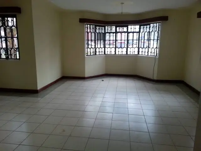 Spacious empty living room with tiled floor and natural light