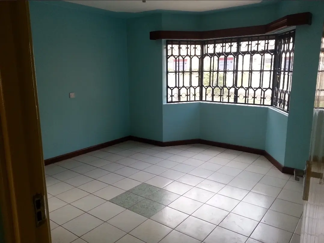 Bright turquoise living room with tiled floor and barred windows