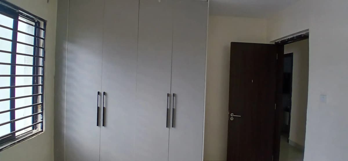 Bedroom with built-in white wardrobes and dark door