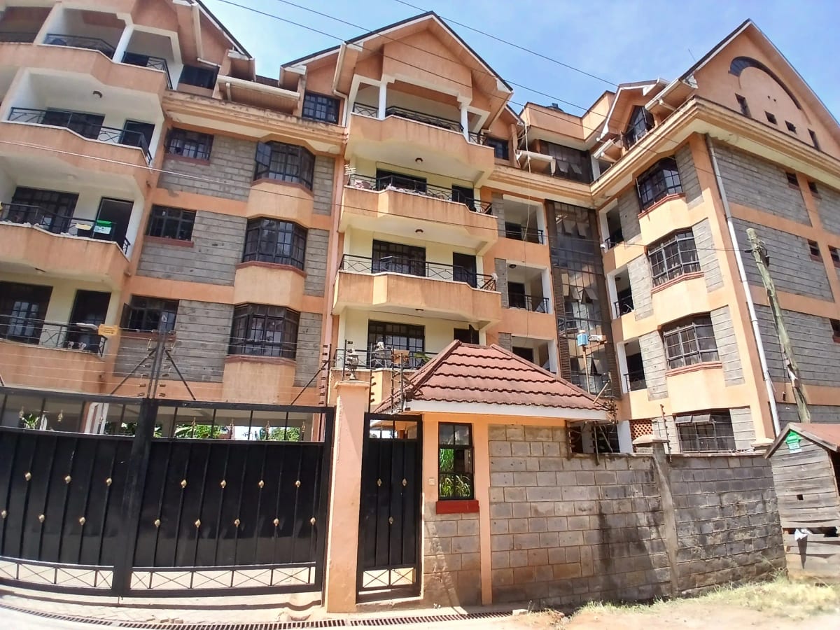 Multi-story residential building with terracotta facade and gated entrance