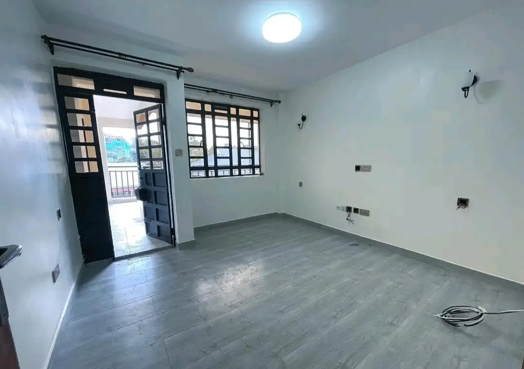 Empty living room with sliding glass doors to balcony