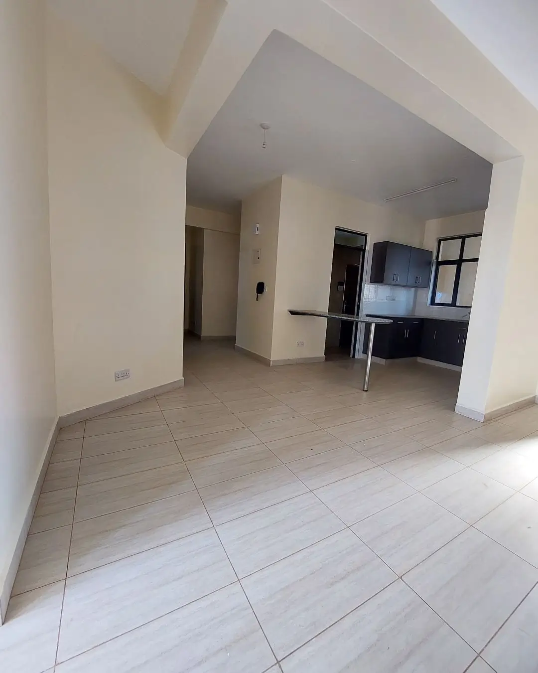 Open-plan living and kitchen area with tiled flooring