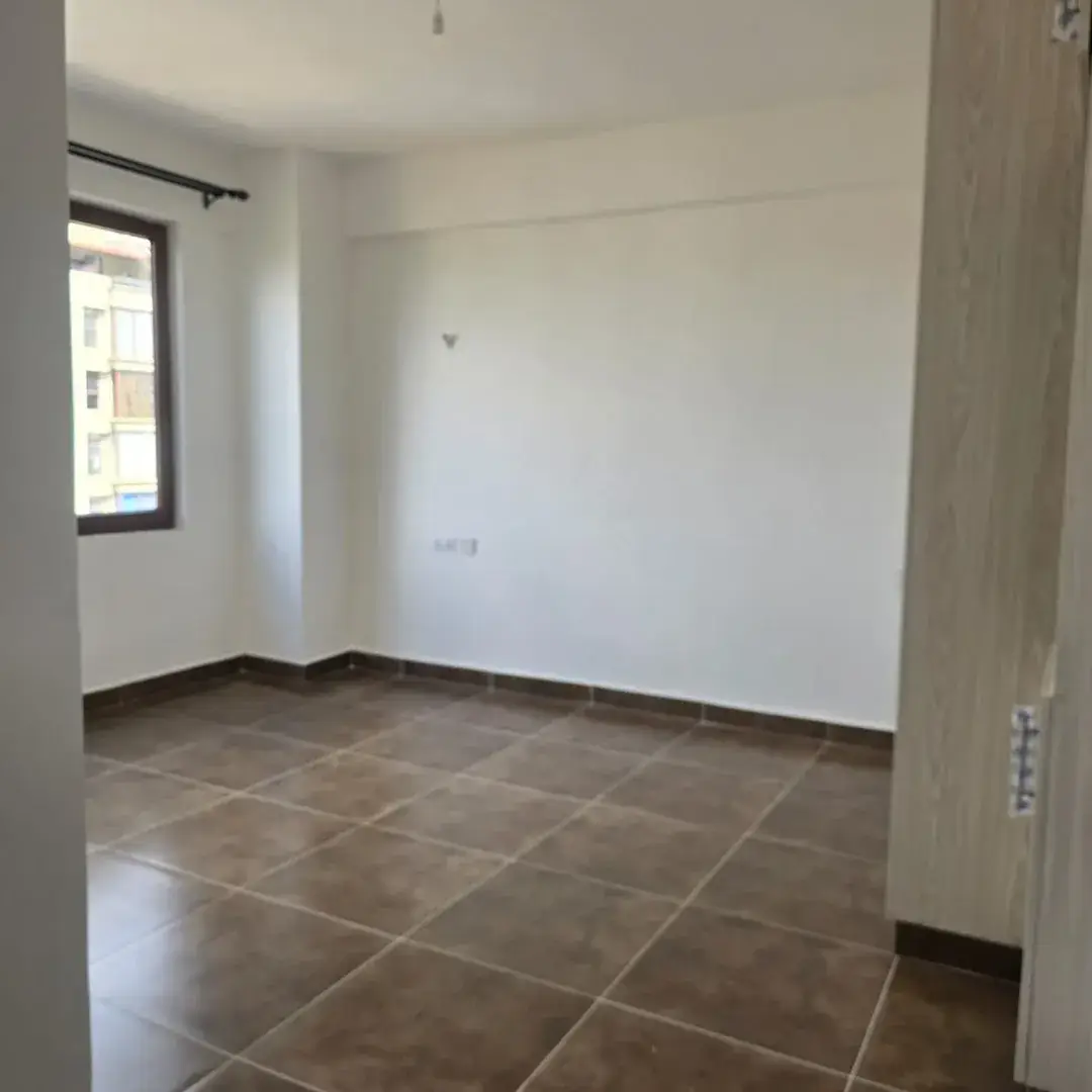 Bright empty living space with tiled flooring and natural light