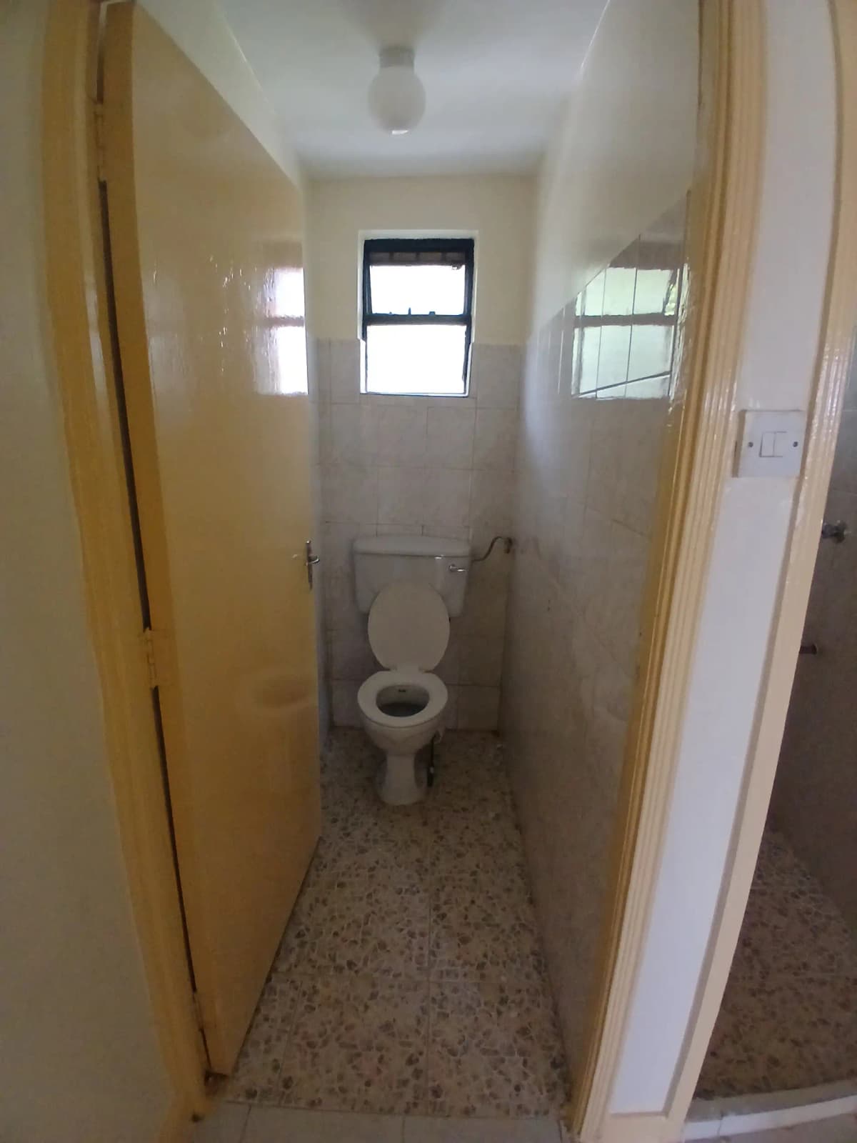 Compact bathroom with toilet and small window