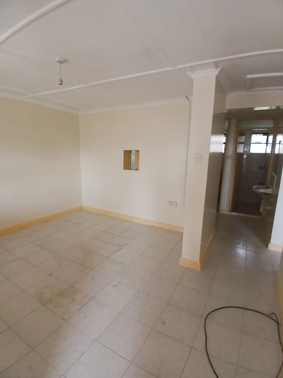 Spacious empty living room with tiled flooring and neutral walls