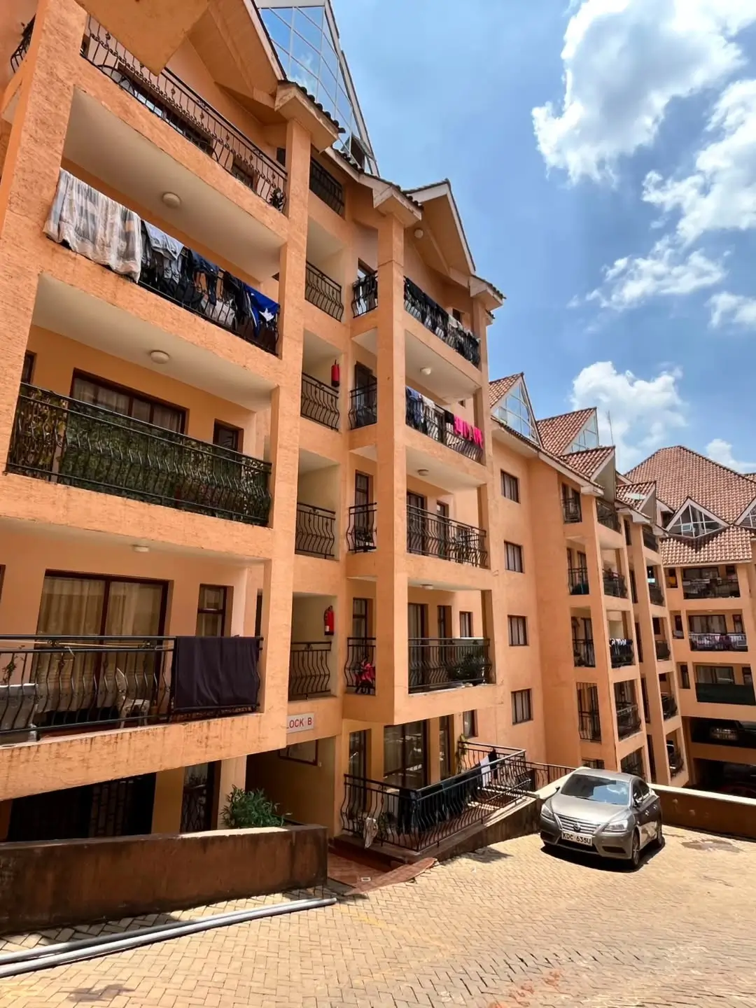 Multi-story residential building with terracotta facade and balconies