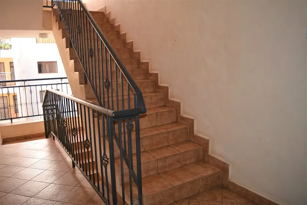 Internal staircase with black metal railings and terracotta steps