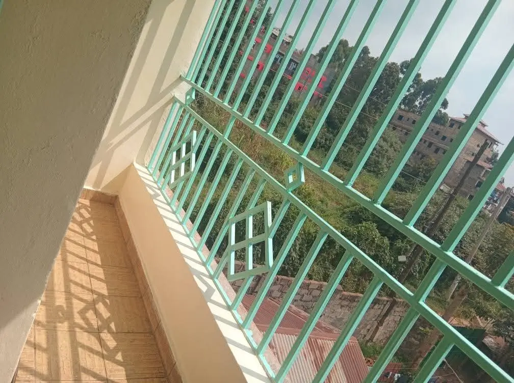 Green-railed balcony with cityscape and residential buildings view