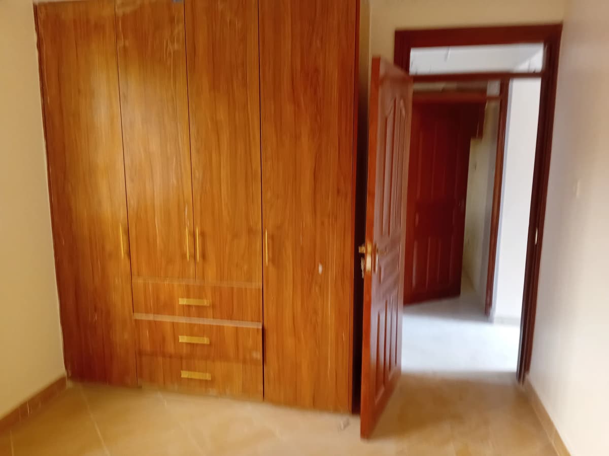 Bedroom with large wooden wardrobe and open doorway
