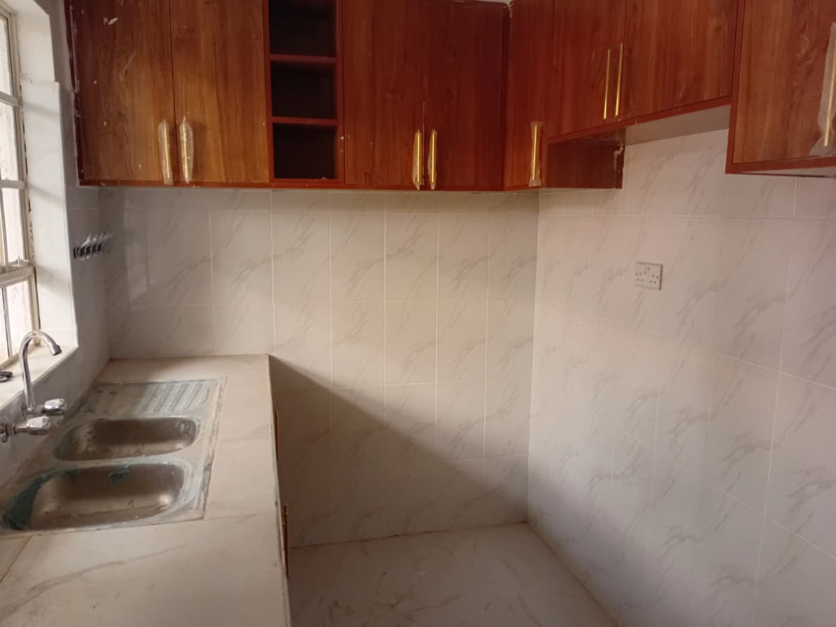 Compact kitchen with wooden cabinets and stainless steel sink