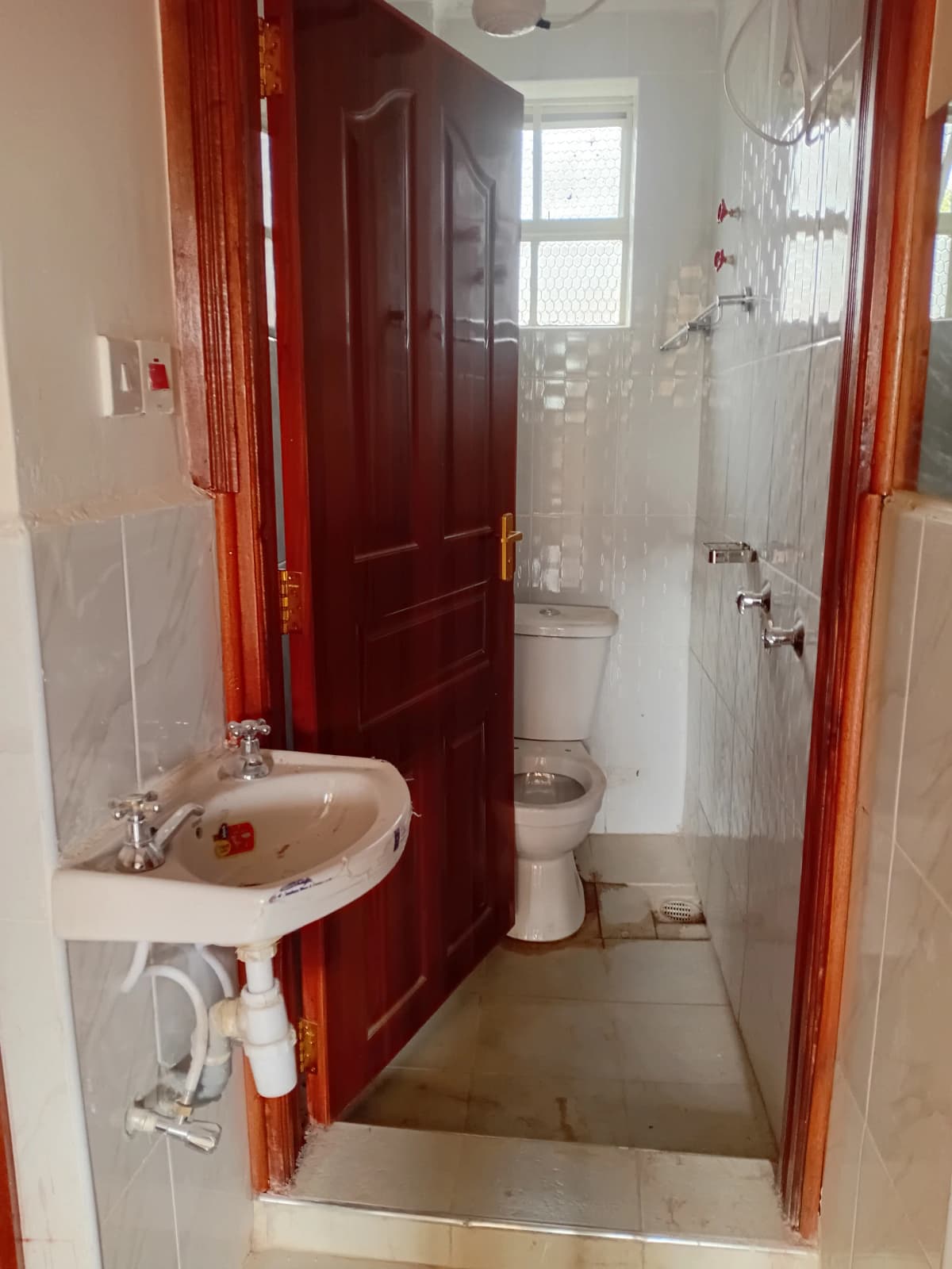 Compact bathroom with sink, toilet, and shower enclosure