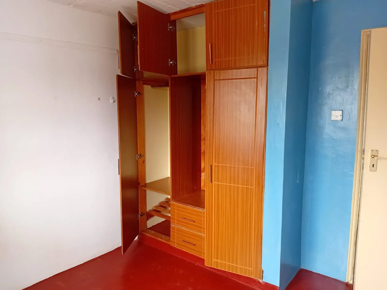 Bedroom with wooden built-in wardrobe and red flooring