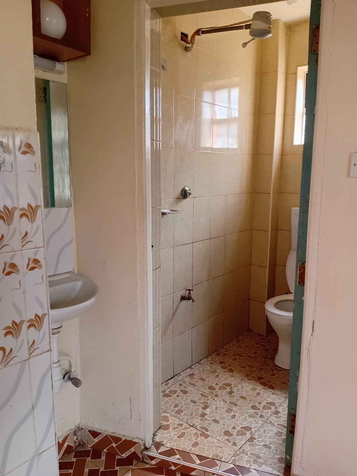 Bathroom with shower enclosure, toilet, sink, tiled walls