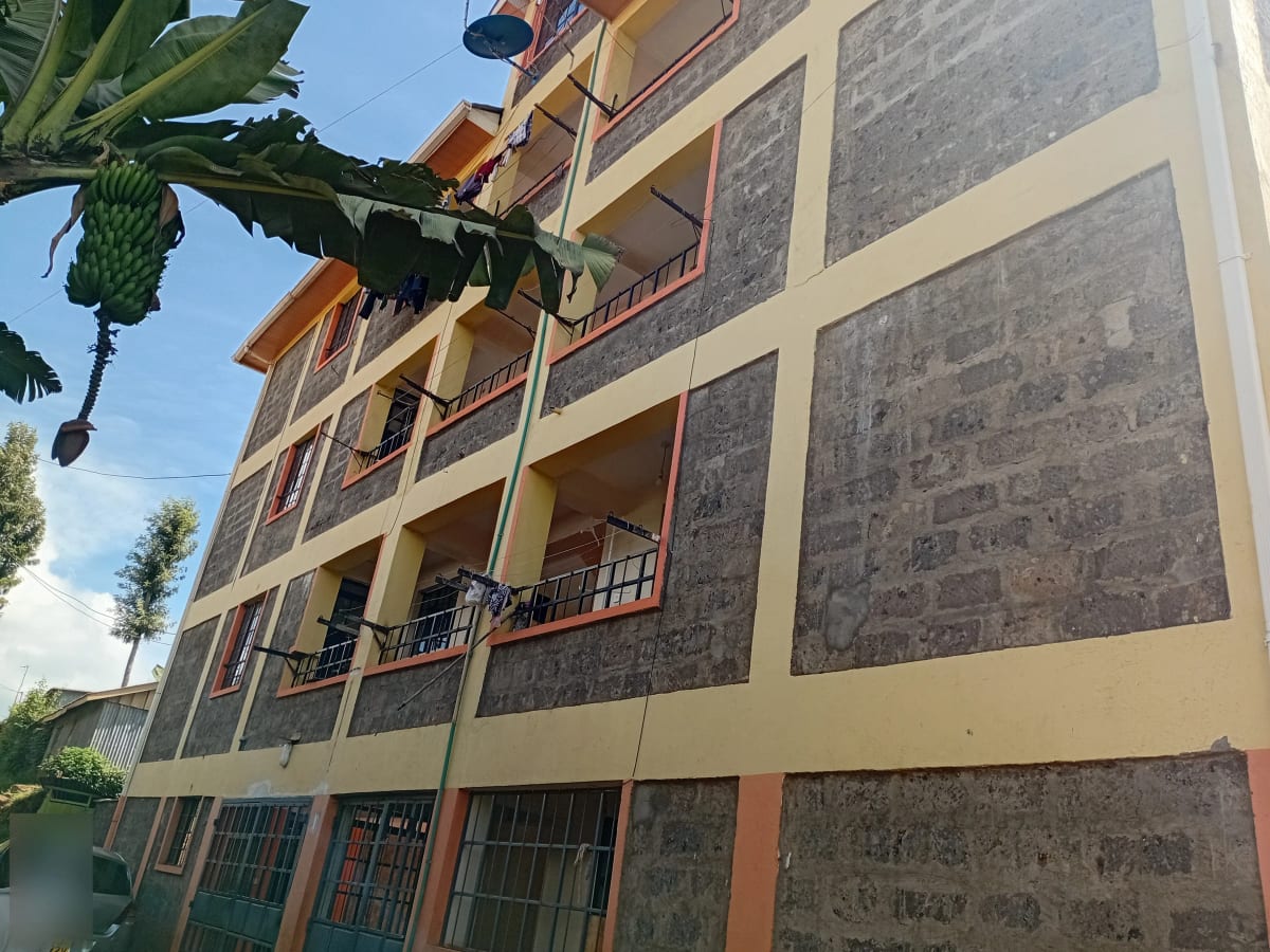Multi-story residential building with balconies and banana plant