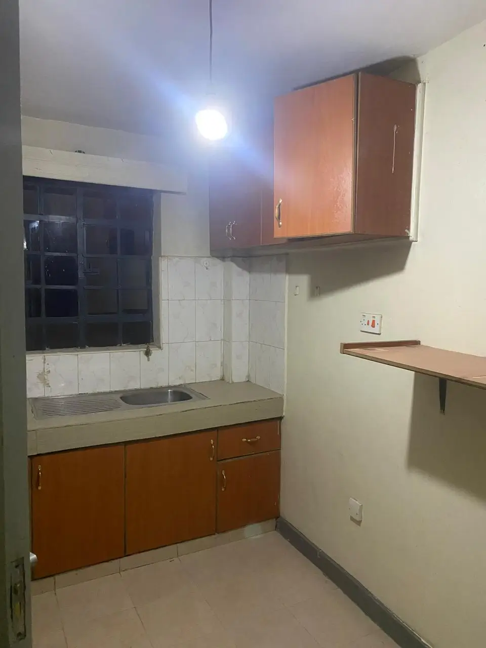 Compact kitchen with wooden cabinets and wall-mounted storage