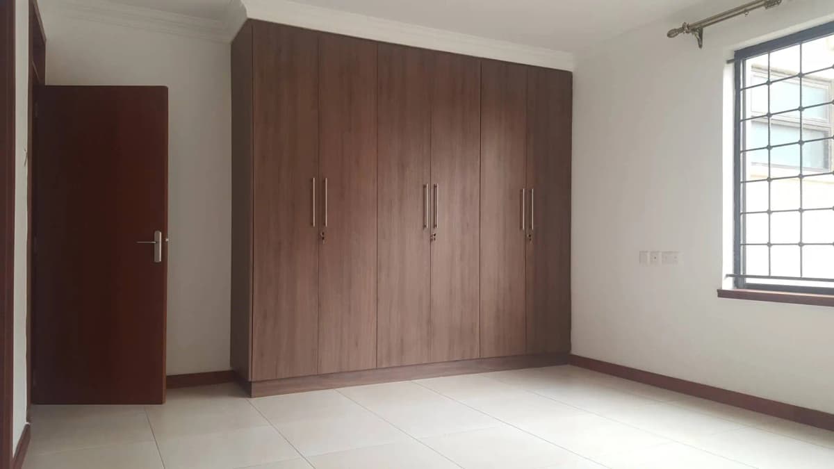 Spacious bedroom with built-in wooden wardrobe storage