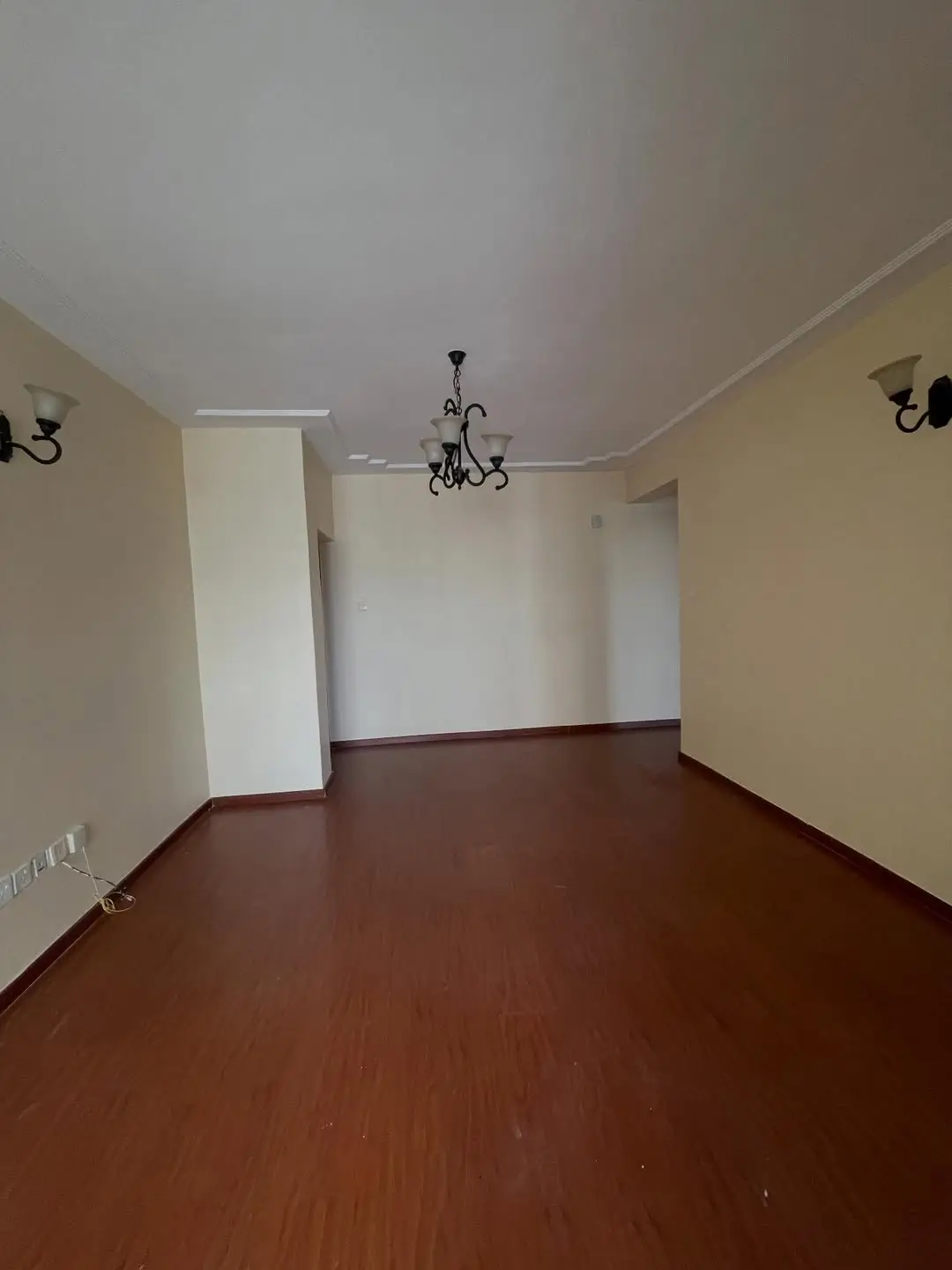 Empty living room with wooden floor and cream walls